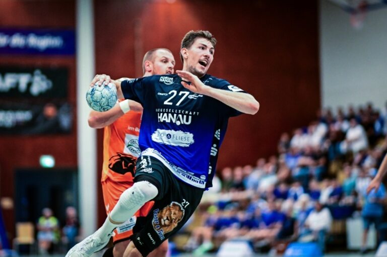 HSG Hanau vor erstem Auswärtsderby der Saison 2025/26 Duell mit dem TV Kirchzell am Samstagabend in Miltenberg Nach einer spielfreien Woche ist die HSG Hanau am Samstagabend wieder in der 3. Liga Süd-West gefordert. Das erste Derby in der noch jungen Saison 2025/26 steht auf dem Plan. Die Mannen um ihren Kapitän Max Bergold reisen zum TV Kirchzell. Anwurf ist um 19:30 Uhr in der Dreifachsporthalle Miltenberg. Mit einem Sieg im Rücken sind Rivic, Schiefer & Co. heiß auf die nächsten beiden Punkte, doch der „Odenwaldexpress“ des TVK ist mit viel Dampf in die neue Runde gestartet. Natürlich fahren wir mit viel Selbstvertrauen und breiter Brust zu diesem Derby nach Kirchzell“, meint HSG-Cheftrainer Axel Spandau. „Wir wollen dort anknüpfen, womit wir beim Auswärtsspiel in Schalksmühle angefangen haben, nämlich Spiele zu gewinnen. Allerdings mit dem vollen Bewusstsein, dass das am Samstag eine schwierige Aufgabe für uns wird.“ Es sind die A