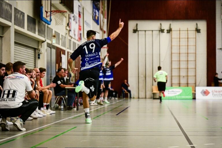 Hanauer Auswärtsserie hält auch in Hochdorf HSG Hanau gewinnt beim HLZ Friesenheim-Hochdorf II mit 33:27 Mit einer deutlichen Leistungssteigerung im zweiten Spielabschnitt hat Handball-Drittligist HSG Hanau seine Auswärtsserie eindrucksvoll fortgesetzt. Die Grimmstädter triumphierten am Sonntagabend mit 33:27 (16:17) beim HLZ Friesenheim-Hochdorf II und haben damit in der Saison 2025/26 in fremden Hallen bereits 9:1 Punkte gesammelt. Mit Beginn der zweiten dreißig Minuten drehten die Blau-Weißen, angeführt von einem starken Lukas Böhm (8 Tore) im Rückraum, merklich auf und legten einen 7:0-Lauf aufs Parkett, von dem sich die Zweitliga-Reserve der Eulen Ludwigshafen nicht mehr erholte. „Ein klarer Auswärtssieg für uns und das obwohl wir die ersten 15 Minuten eigentlich kaum anwesend waren“, meinte HSG-Cheftrainer Axel Spandau nach Spielende. „Allerdings, die zweite Hälfte war dann eine richtig geile Halbzeit, in der es wirklich Spaß gem