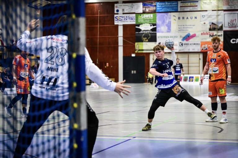 Auswärtssieg nach hochspannender Schlussphase HSG Hanau nimmt auch aus Ratingen zwei Punkte mit nach Hause Die Handballer aus der Brüder-Grimm-Stadt Hanau bleiben weiterhin in der Saison 2025/26 auswärts ungeschlagen. Am späten Sonntagnachmittag gelang der HSG Hanau ein hart erkämpfter 30:28 (14:15)-Erfolg beim Drittliga-Aufsteiger Interaktiv.Handball Düsseldorf-Ratingen und das vor allem dank einer bärenstarken Schlussphase von Rivic, Hein & Co. Nun richten sich alle Augen auf das anstehende Heimderby, in welchem die Mannschaft dann auch endlich den ersten Sieg vor eigenen Zuschauern feiern will. „Wir sind natürlich über diesen Auswärtserfolg, den fünften in dieser Saison, sehr glücklich“, erklärte HSG-Chefcoach Axel Spandau im Anschluss an die Partie. „In der ersten Halbzeit haben wir noch etwas fahrig gespielt, doch später hat die Mannschaft klare taktische Disziplin gezeigt.“ Mit 11:1 Punkten aus den letzten sechs Spielen in der Fremde beweist sic