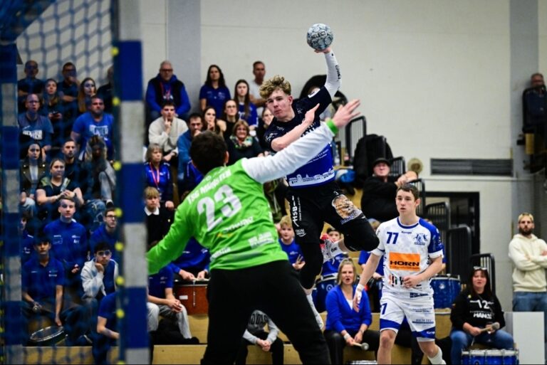 Hanauer Knoten platzt beim überzeugenden Heimsieg gegen Münster HSG Hanau gewinnt das Rhein-Main-Derby gegen die TSG Münster mit 30:27 Im vierten Anlauf holt die HSG Hanau den ersten Heimsieg der Saison 2025/26 in der 3. Liga Staffel Süd-West – und das ausgerechnet im Rhein-Main-Derby gegen die bislang stark aufspielende TSG Münster. Am Freitagabend zeigten die Grimmstädter, angeführt von ihrem Youngster Sebastian Hein (8 Tore), gegen den Aufsteiger aus Kelkheim eine extrem abgeklärte Mannschaftsleistung. 600 Zuschauer in der Main-Kinzig-Halle honorierten das eindrucksvolle 30:27 (14:8) mit donnerndem Applaus. „Wir haben heute eine überragende erste Halbzeit gespielt“, äußerte sich HSG-Coach Axel Spandau nach dem Heimsieg hocherfreut am Mikrofon. „Durch unseren zweikampfstarken Kern in der Deckung und unseren Benedikt Müller im Tor kam Münster überhaupt nicht zur Entfaltung.“ WIR & IHR – GEMEINSAM! Hauptsponsor des vierten Hei